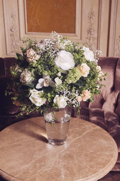 Bouquet of white roses on marble table in interior of the Baroque style