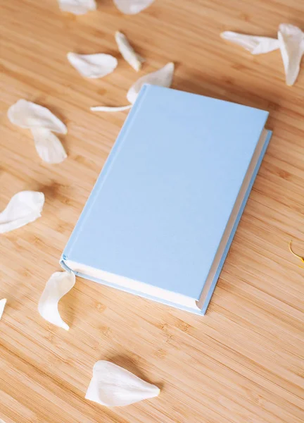 Şakayık Çiçeği ve mavi arka plan üzerine açık mavi kitap