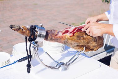 Serrano jambonu bir ön bacak olarak da bilinen İspanyol İber jambon ya da Pata Negra bir ahşap stand bu bir kasap kesim dilimleri ile monte