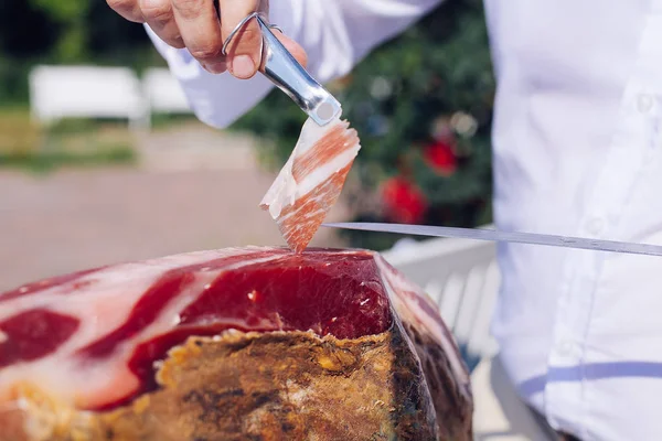 Serrano jambonu bir ön bacak olarak da bilinen İspanyol İber jambon ya da Pata Negra bir ahşap stand bu bir kasap kesim dilimleri ile monte