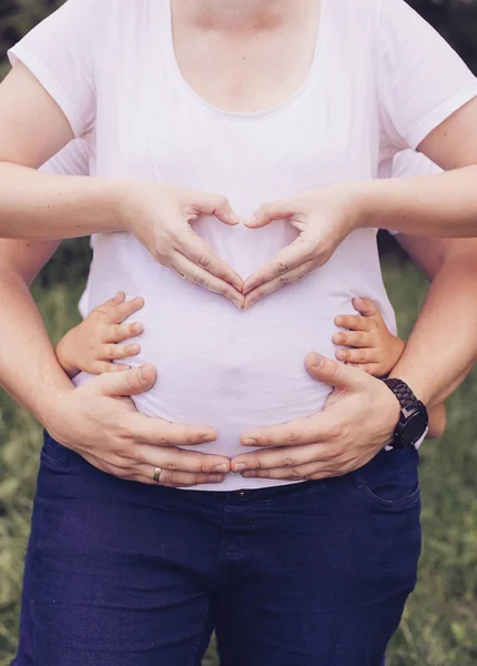 Photos rapprochées du ventre de la femme enceinte avec les mains — Photo