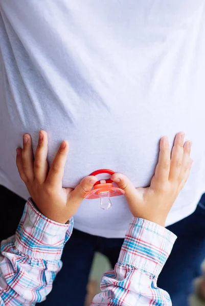 Pregnant woman and her young daughter's hands holding baby's dum — Stock Photo, Image