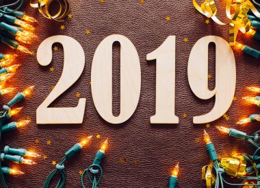 Noel ve yeni yıl kompozisyon. 2019 simbols ve kahverengi deri arka plan üzerinde garland. Düz yatıyordu, en iyi görünümü