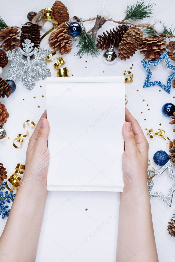 Woman hands with notepad on Christmas and New Year background. To do list or list of promises, place for your text