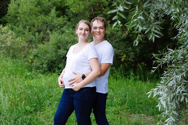 愉快的孕妇和她的丈夫在夏天公园 — 图库照片
