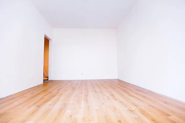 Photo of a white empty scandinavian room interior with wooden floor and walls. Home nordic interior.