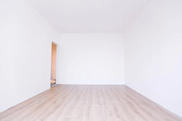 Photo of a white empty scandinavian room interior with wooden floor and walls. Home nordic interior.