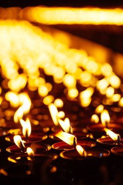 Birçok alan sığ derinliği ile karanlıkta parlayan alevler mum