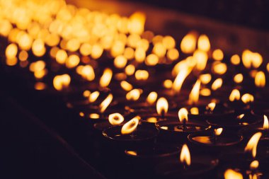 Birçok alan sığ derinliği ile karanlıkta parlayan alevler mum