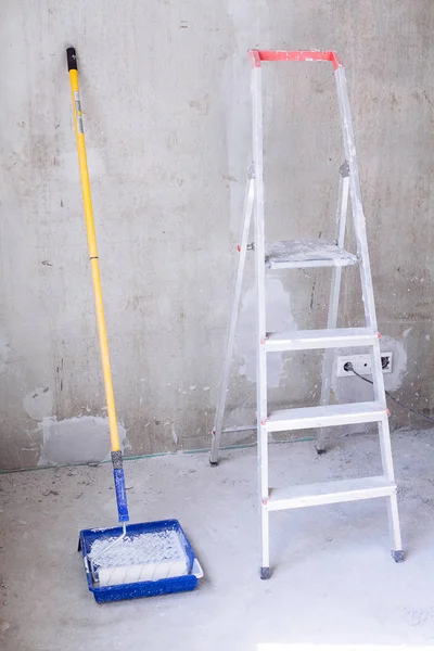 Cubo azul con pintura, bandeja de pintura con rodillo de pincel y escalera — Foto de Stock