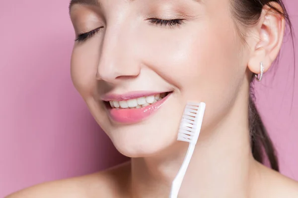 Mooie jonge vrouw glimlachend met tandenborstel — Stockfoto