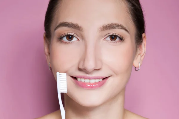 Красива молода жінка посміхається зубною щіткою — стокове фото