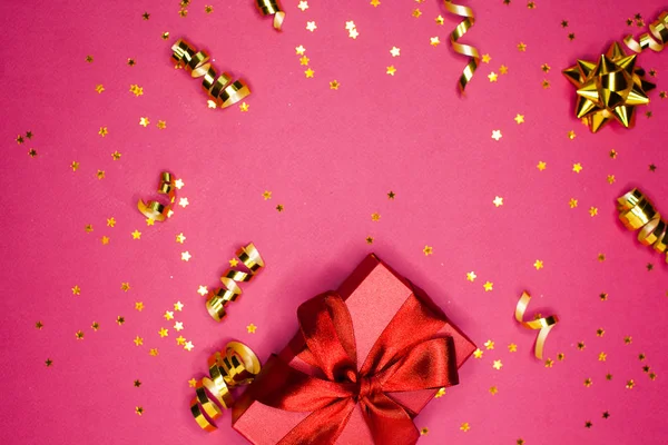 Coffret cadeau et décorations dorées et étincelles sur rose vif — Photo