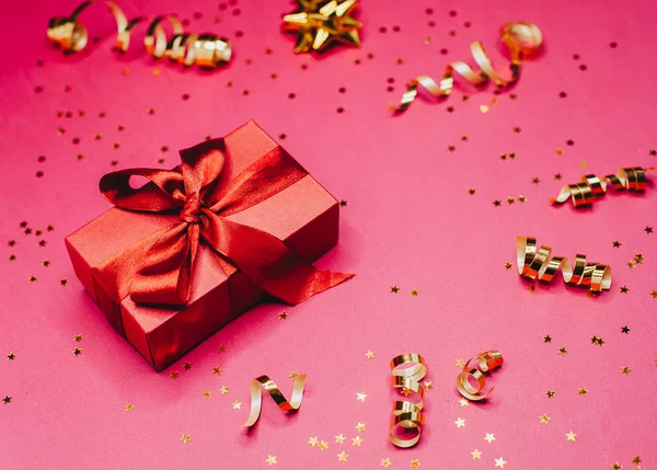 Caja de regalo y decoraciones doradas y destellos en rosa brillante —  Fotos de Stock