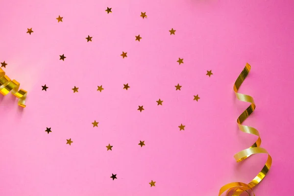 Decoraciones y destellos dorados sobre fondo rosa —  Fotos de Stock
