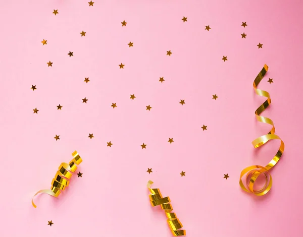Decoraciones y destellos dorados sobre fondo rosa —  Fotos de Stock