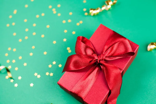Caja de regalo y decoraciones de oro y destellos en ba verde brillante —  Fotos de Stock