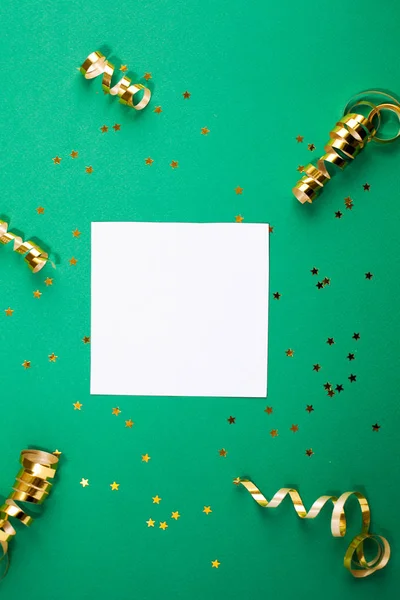 Hoja de papel blanco, decoraciones doradas y destellos en la espalda verde —  Fotos de Stock