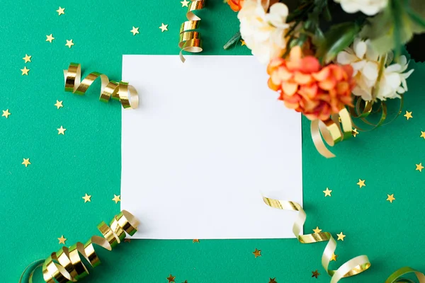 White paper sheet, golden decorations and sparkles on green back