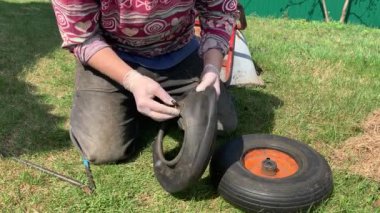 Bir çiftlik bahçesinde yeşil çim çim üzerinde El Arabası yeni lastik değiştirme 