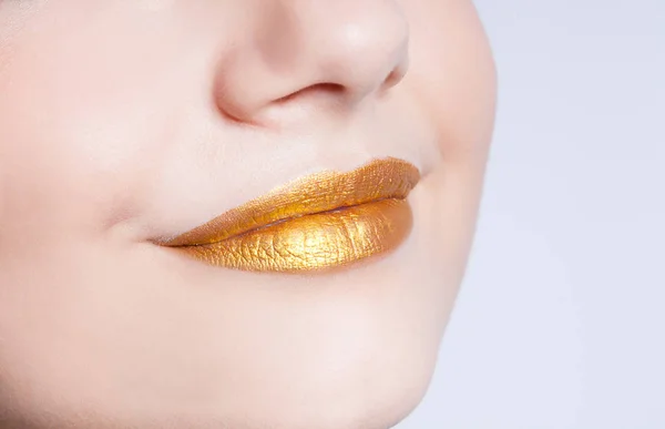 Hermosos labios femeninos de primer plano con maquillaje de color oro —  Fotos de Stock