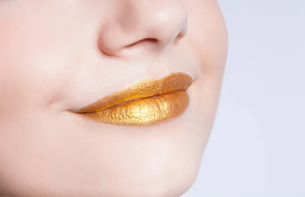 Mooie close-up vrouwelijke lippen met gouden kleur make-up — Stockfoto