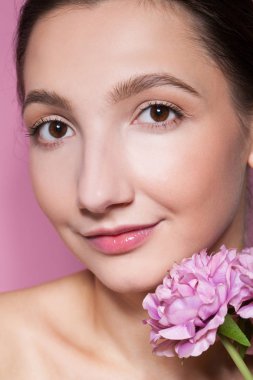 Pembe arka planda çiçekli güzel bir kadın.. 
