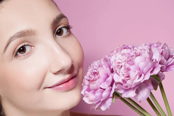 Giovane bella donna con fiore su sfondo rosa . — Foto Stock