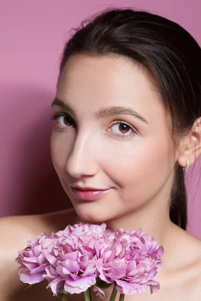Joven hermosa mujer con flor sobre fondo rosa . — Foto de Stock