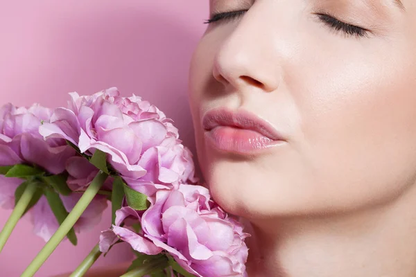 Jovem mulher bonita com flor no fundo rosa . — Fotografia de Stock