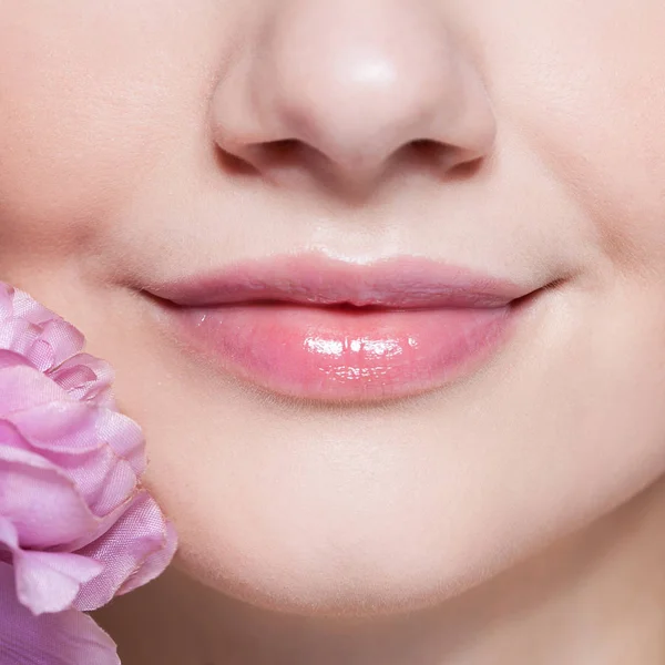 Jovem mulher bonita com flor no fundo rosa . — Fotografia de Stock