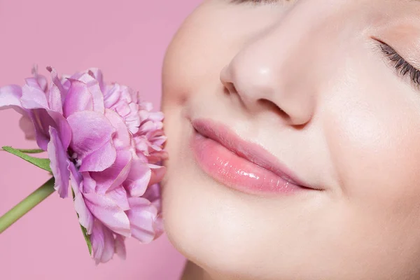 Joven hermosa mujer con flor sobre fondo rosa . —  Fotos de Stock