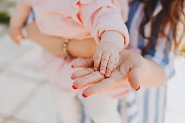 Mãe delicadamente segurando dedos do bebê — Fotografia de Stock