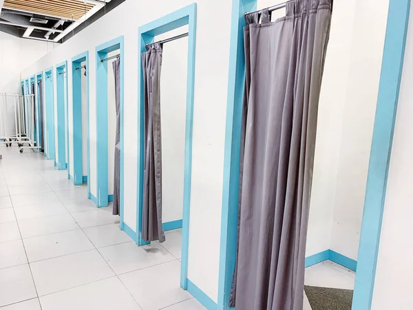 Empty fitting rooms with grey curtains and white walls