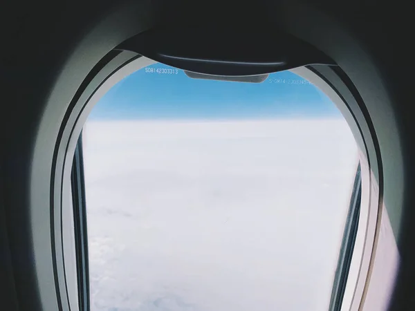 Plane window view with blue sky and clouds. — Stock Photo, Image