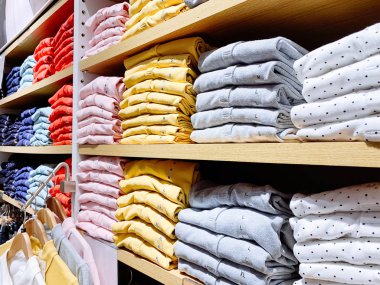 Dükkanda pamuklu t-shirt yığını. Ahşap rafta T-Shirt çeşitli boyutlarda