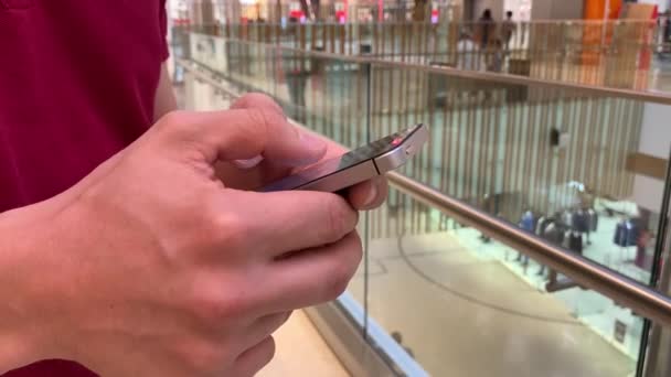 Mani di giovane utilizzando smartphone nel centro commerciale. Comunicazione, shopping online, chat, social network — Video Stock