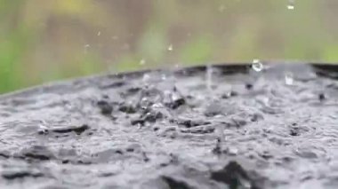 Yağmur damlaları su yüzeyine düşüyor. Şiddetli yağmur, su sıçramaları