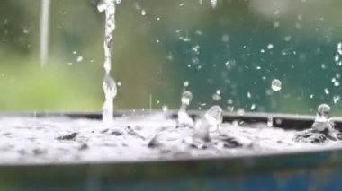 Yağmur damlaları su yüzeyine düşüyor. Şiddetli yağmur, su sıçramaları