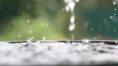 Yağmur damlaları su yüzeyine düşüyor. Şiddetli yağmur, su sıçramaları