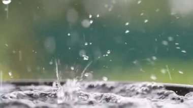 Yağmur damlaları su yüzeyine düşüyor. Şiddetli yağmur, su sıçramaları