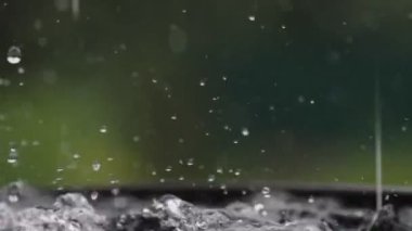 Yağmur damlaları su yüzeyine düşüyor. Şiddetli yağmur, su sıçramaları