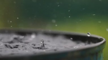 Yağmur damlaları su yüzeyine düşüyor. Şiddetli yağmur, su sıçramaları