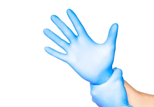 Доктор надевает перчатки изолированные на белом — стоковое фото