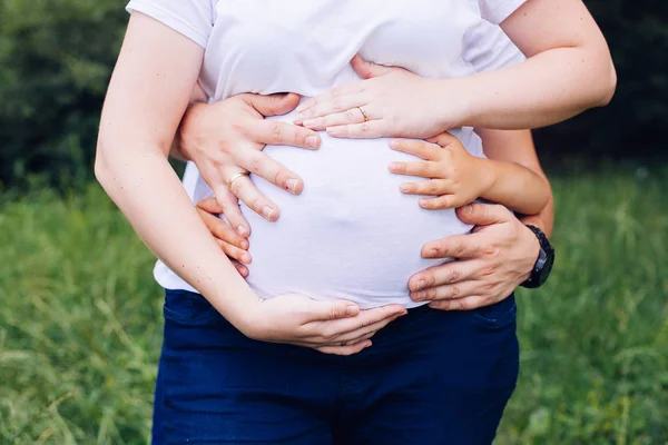 Close-up fotos da barriga da mulher grávida com as mãos — Fotografia de Stock