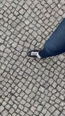 Siyah spor ayakkabılı ayaklar sett yol üzerinde adım şehir üzerinde yürüyor