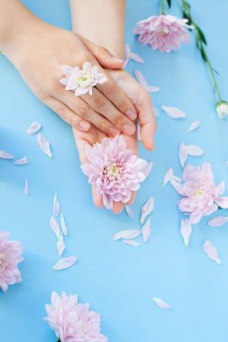 Açık mavi üzerinde pembe çiçekli kadın elleri yakın fotoğraf 