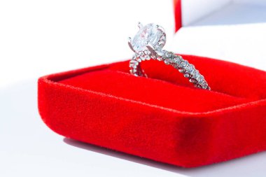 Beyaz arka planda kırmızı kutuda elmas nişan yüzüğü.