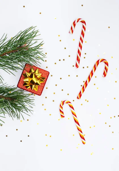 Composition de Noël. Branche de sapin, boîte cadeau rouge, canne à bonbons — Photo