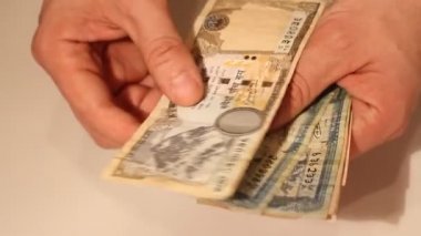 Adamın elleri Nepal banknotlarını sayıyor. Nepal Ulusal Para Birimi (NPR)